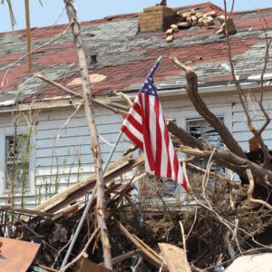 A,Us,American,Flag,Rises,Above,A,Home,Ruined,By