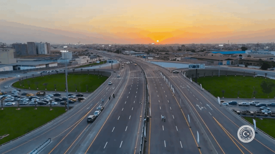 A large freeway intersection in the middle of a city, at dawn.