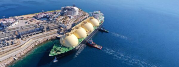 A large, oil tanker docked at an industrial port.