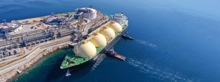 A large, oil tanker docked at an industrial port.